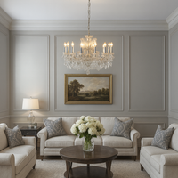 This grand twelve-arm chandelier blends a silver frame with layers of sparkling crystals, creating a soft, romantic glow that brings elegance to any room.