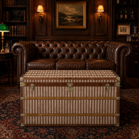 Vintage striped steamer trunk with brown trim and brass fittings in a library room
