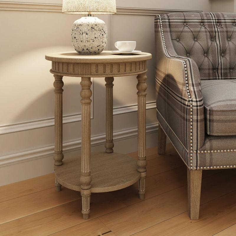 A vintage-inspired limewashed round wooden side table with turned fluted legs and a lower shelf, photographed against a neutral backdrop.
