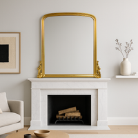 Antique giltwood overmantle mirror with arched top and ornate scrollwork base, finished in aged gold leaf, styled for traditional fireplace décor.