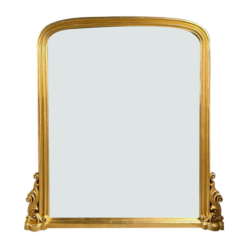 Antique giltwood overmantle mirror with arched top and ornate scrollwork base, finished in aged gold leaf, styled for traditional fireplace décor.
