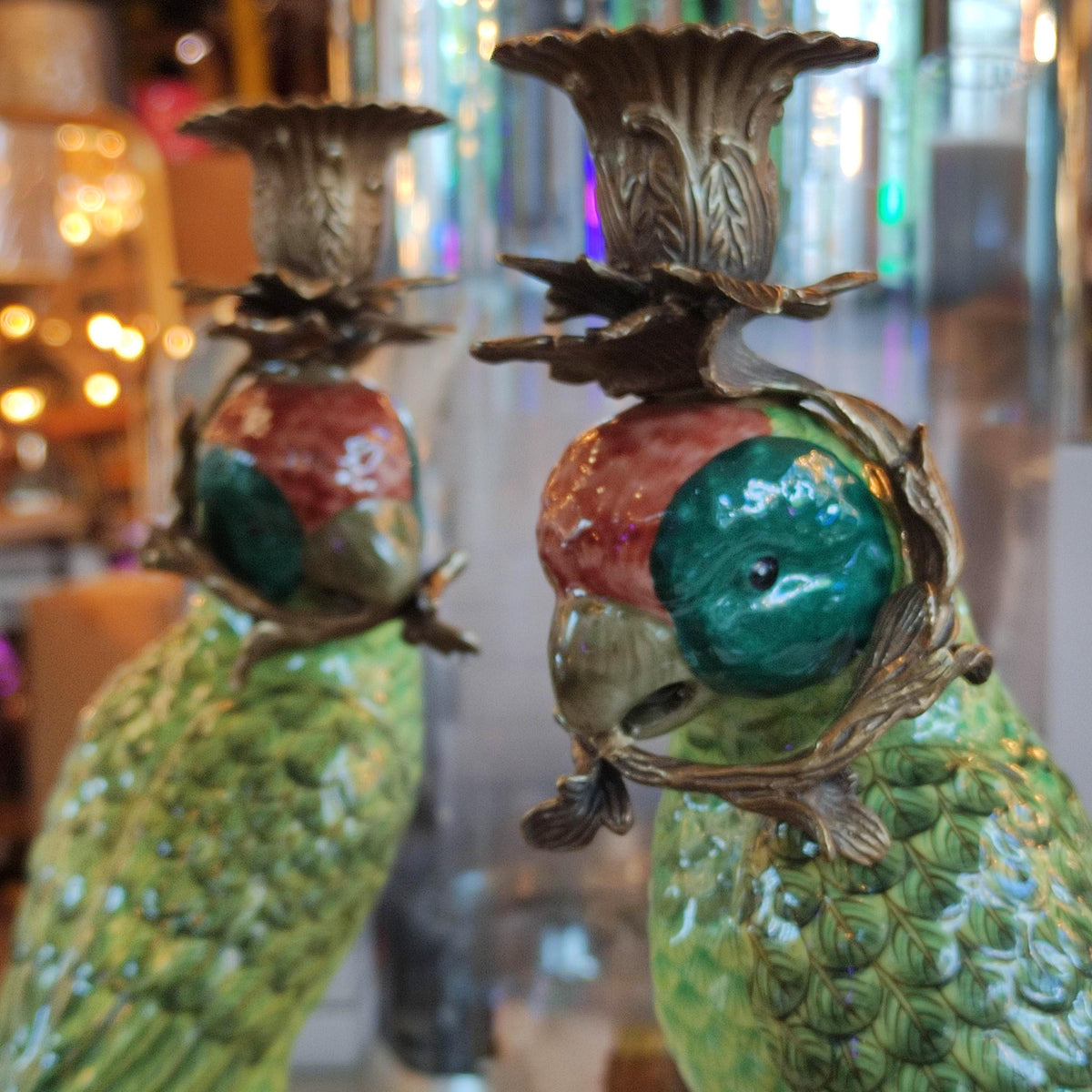 Pair of bronze and coloured porcelain parrot candle holders on ornate bases.