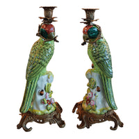 Pair of bronze and coloured porcelain parrot candle holders on ornate bases.