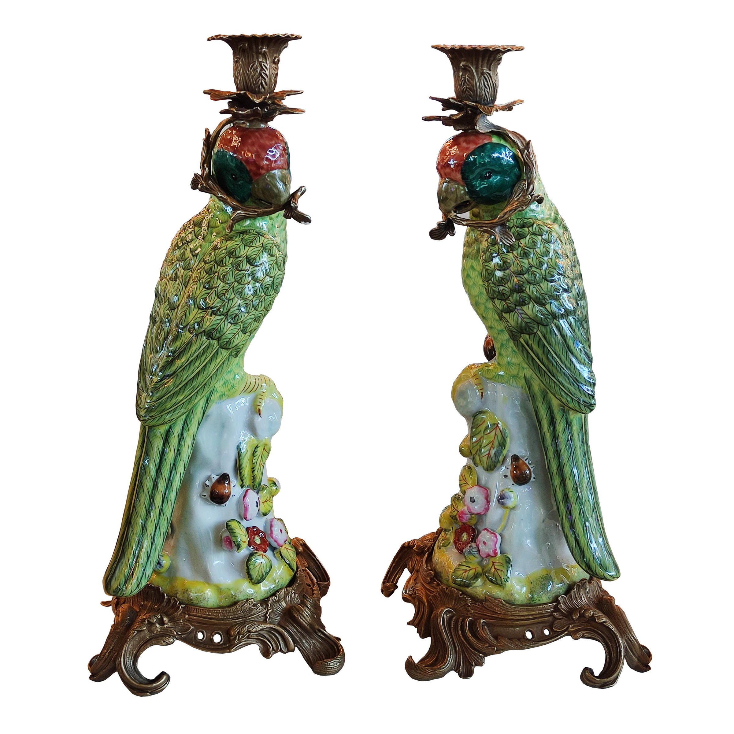 Pair of bronze and coloured porcelain parrot candle holders on ornate bases.