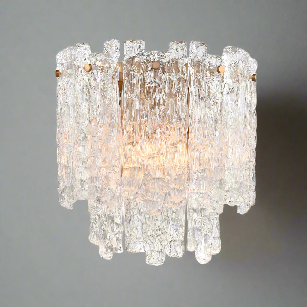 Icicle shard wall light with textured glass panels at varying heights to refract the lights. It has 2 lights and aged brushed brass metal fittings. A totally luxurious wall light, perfect with the 'Winter Wonderland' range of chandeliers. Would add a touch of luxury to any room.