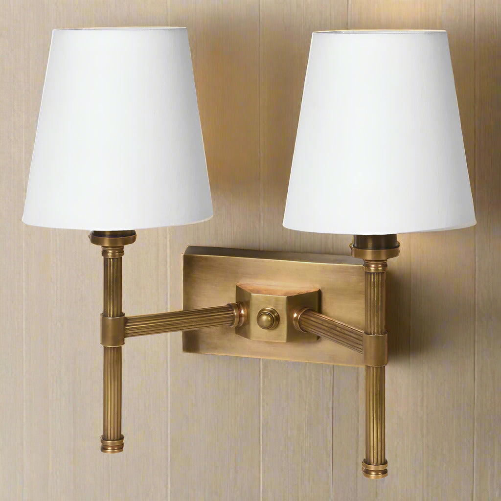 Double rubbed antique brass ribbed wall light with two fabric shades.&nbsp; The sturdy wall light is perfect for a living room or a bedroom.&nbsp;&nbsp; You get the added bonus of twice the amount of light, in a dark hallway or landing. The addition of two fabric shades allows the light to stream out.&nbsp;