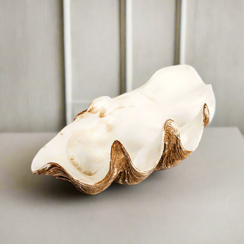 Realistic resin clam shell bowl with natural textures and white interior used as decorative home accent.