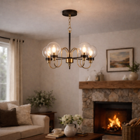 Chandelier hanging in a living room with a fireplace and decor.