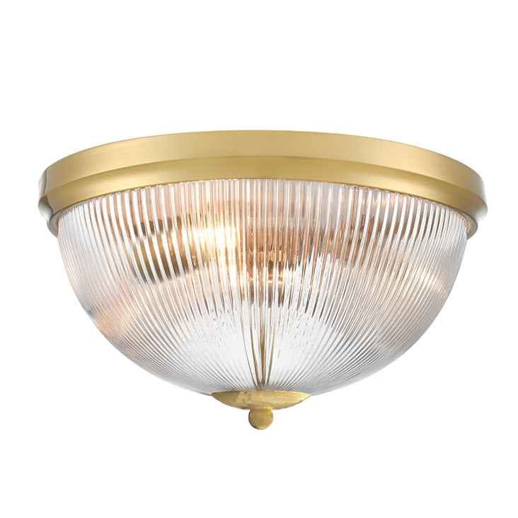 Flush mount ceiling light with ribbed clear glass dome and brass trim.
