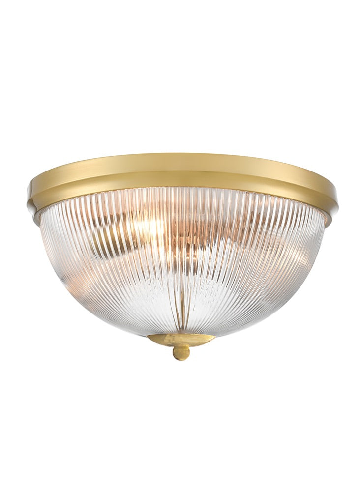 Flush mount ceiling light with ribbed clear glass dome and brass trim.