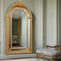 Extremely ornate arched gold mirror with beveled panels. This statement mirror would look amazing in a hallway, just opening up the space and adding a luxurious air to your entryway. In a living room to flash out light and give the illusion of extra space. Stunning rococo revival style with swags and medallions to the crown and heavily ornamented frame. The gilding is a beautifully opulent gilt leaf giving the frame an opulent lustre.

There is no room in the house that would not ben