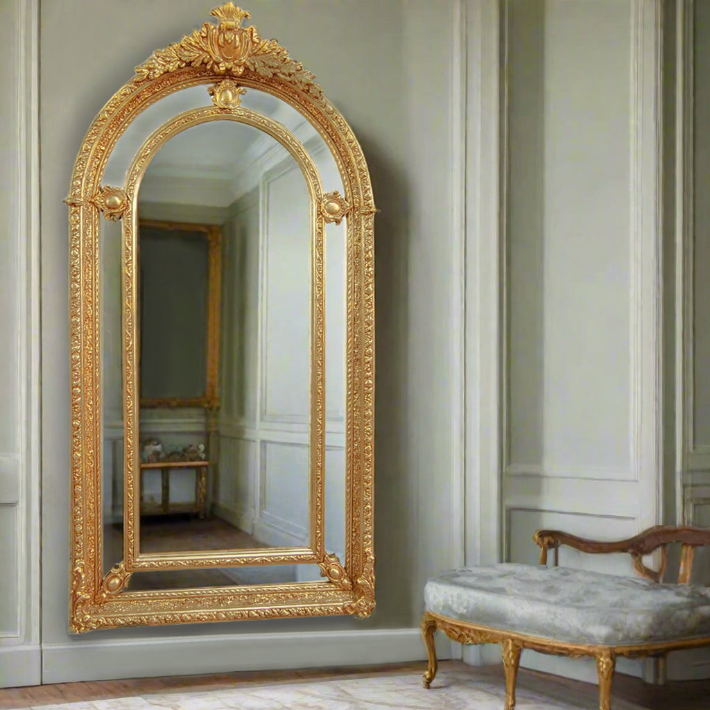 Extremely ornate arched gold mirror with beveled panels. This statement mirror would look amazing in a hallway, just opening up the space and adding a luxurious air to your entryway. In a living room to flash out light and give the illusion of extra space. Stunning rococo revival style with swags and medallions to the crown and heavily ornamented frame. The gilding is a beautifully opulent gilt leaf giving the frame an opulent lustre.

There is no room in the house that would not ben