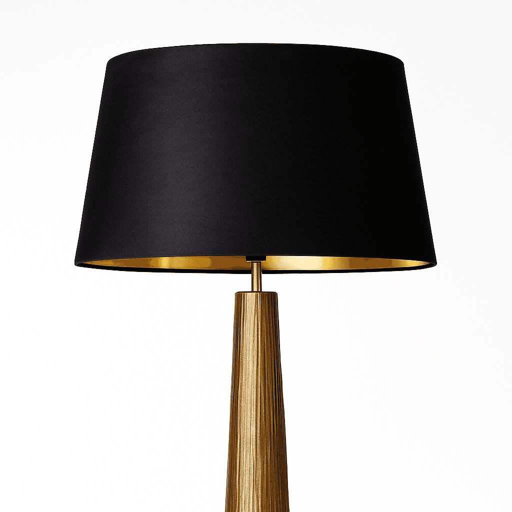 Table lamp with black shade and gold base on a white background