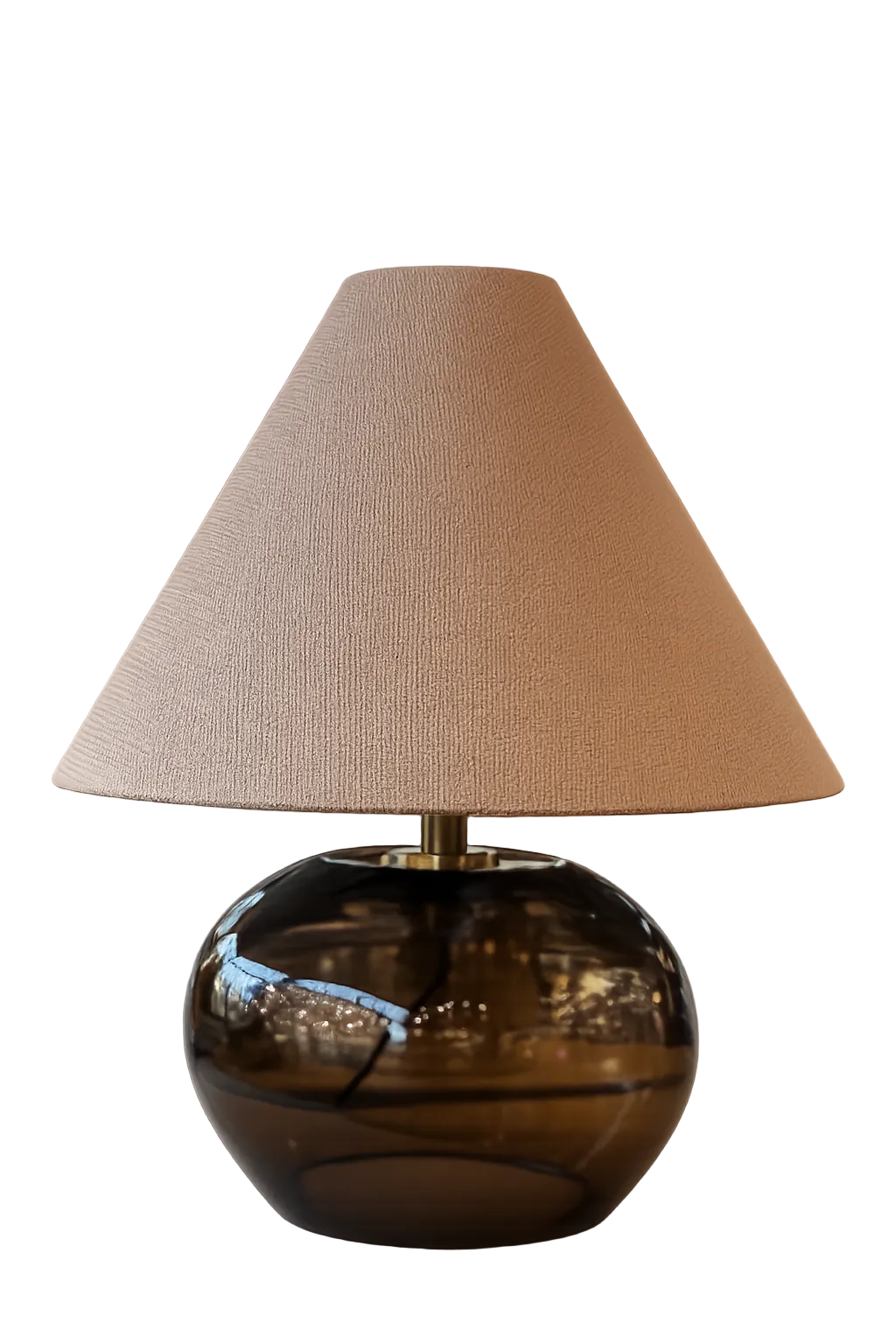 Table lamp with a brown glass base and beige fabric shade on a white background