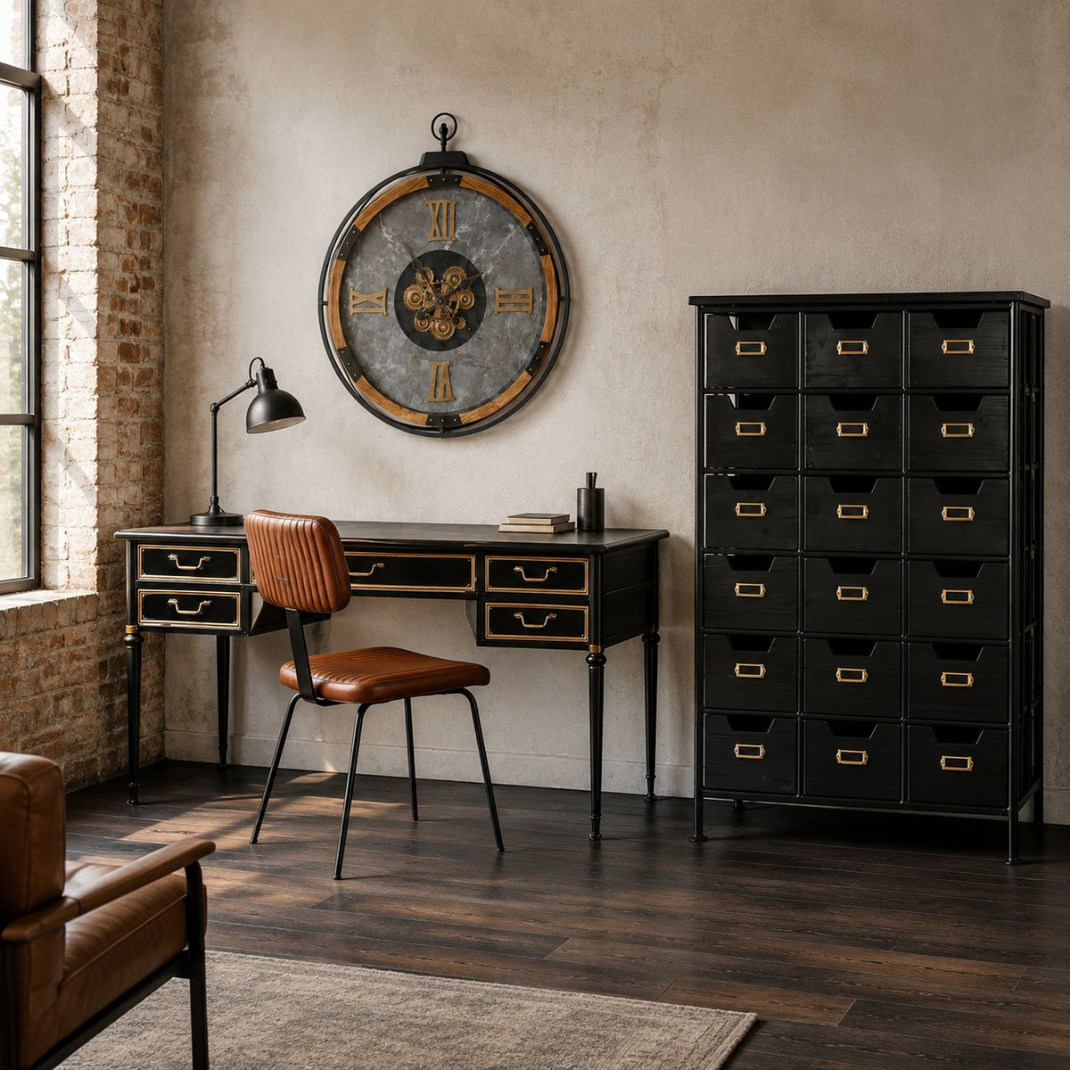 A styled interior room featuring a black writing desk with gold-trimmed drawers, a matching chair, a large round wall clock, and a tall black storage cabinet with gold drawer pulls against a textured beige wall.
