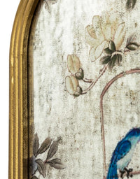 Detail of painted mirror in a gilt arched frame set on a plain background.