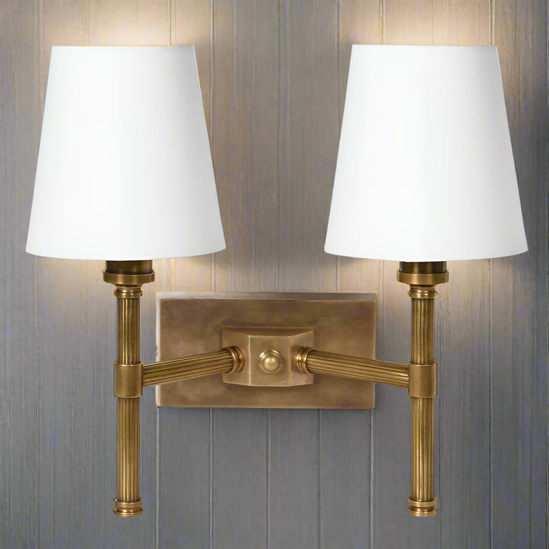 Double rubbed antique brass ribbed wall light with two fabric shades.&nbsp; The sturdy wall light is perfect for a living room or a bedroom.&nbsp;&nbsp; You get the added bonus of twice the amount of light, in a dark hallway or landing. The addition of two fabric shades allows the light to stream out.&nbsp;