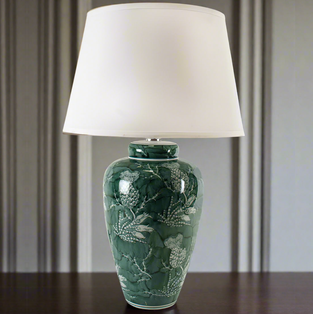 &nbsp;An unusual take on the classic blue and white, this stunning thistle patterned green and white lamp is so perfect with a large white shade. A particularly stunning colour a really vibrant green showing the thistle pattern,&nbsp; When illuminated through the pale coloured linen shade the light from the lamp will enhace the light in any room. Perfect on a console table behind a sofa or a hll. Check our website for a range of large ceramic lamps and shades.


H: 70 cm W: 43 cm