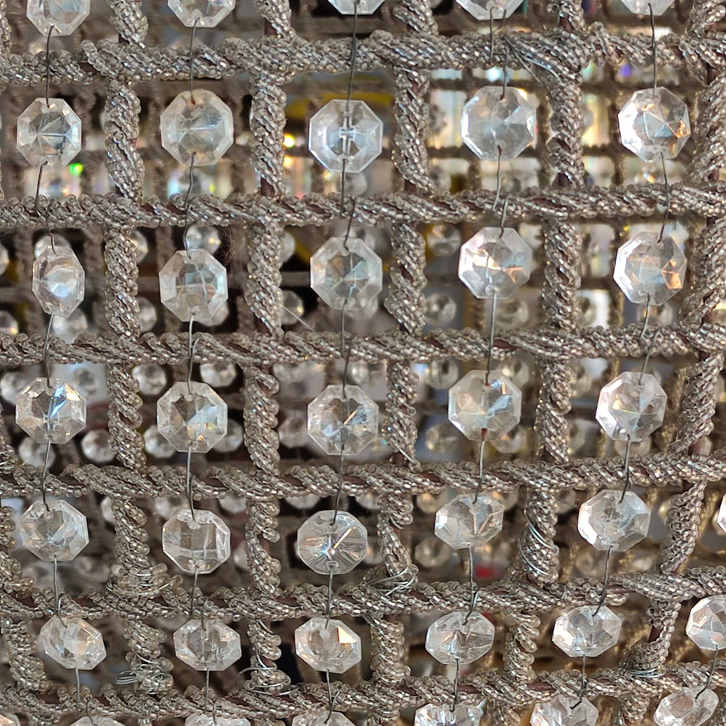  large, aged brass crystal globe chandelier with crystal beading encased in brass metalwork that reflects a pretty pattern around your ceiling and walls. 