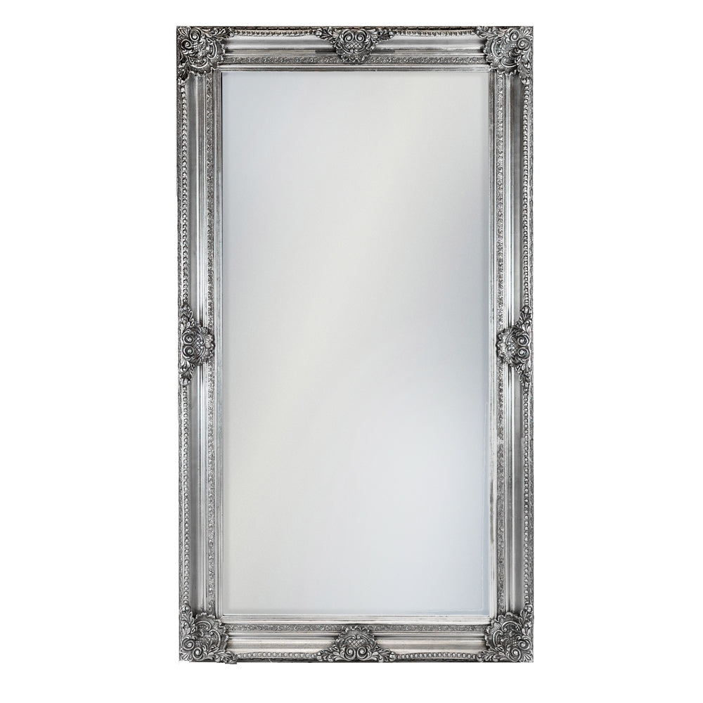 Oversize, silver rococo framed mirror with carved detail on a neutral background.