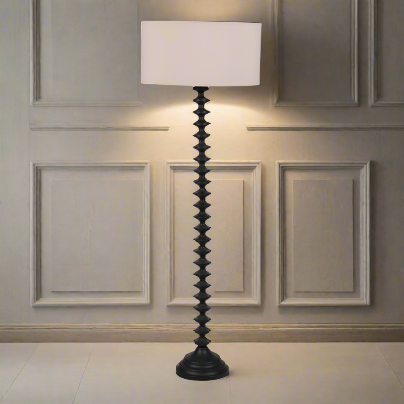 Black wooden floor lamp and linen coloured shade. The wooden base of the lamp is ridged.Particularly decorative floor lamp, simple but so effective with the contrast between the black base and the natural linen shade. Would work well in most interiors, perfect in a living room just to add light from a height and perspective to your room. This is a classsic, traditional black wooden shape for a floor lamp, so would work well in a period town home or a country house.