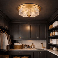 Luxurious laundry room with dark wood cabinets, a gold ceiling light fixture, and various laundry items.