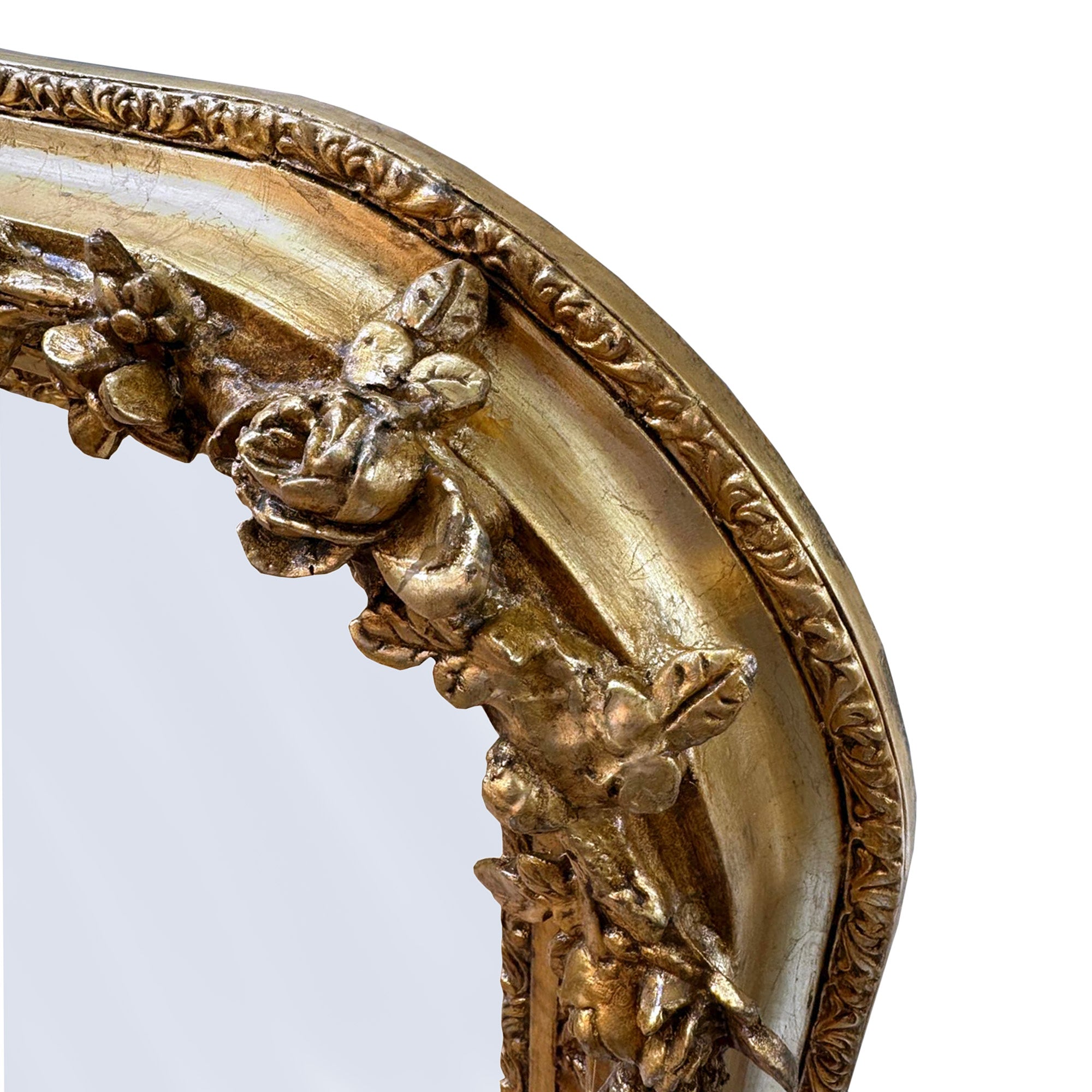 Close-up of an ornate gold mirror frame with intricate detailing on a white background