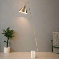 Modernist gilt floor lamp with satin brass shade in living room