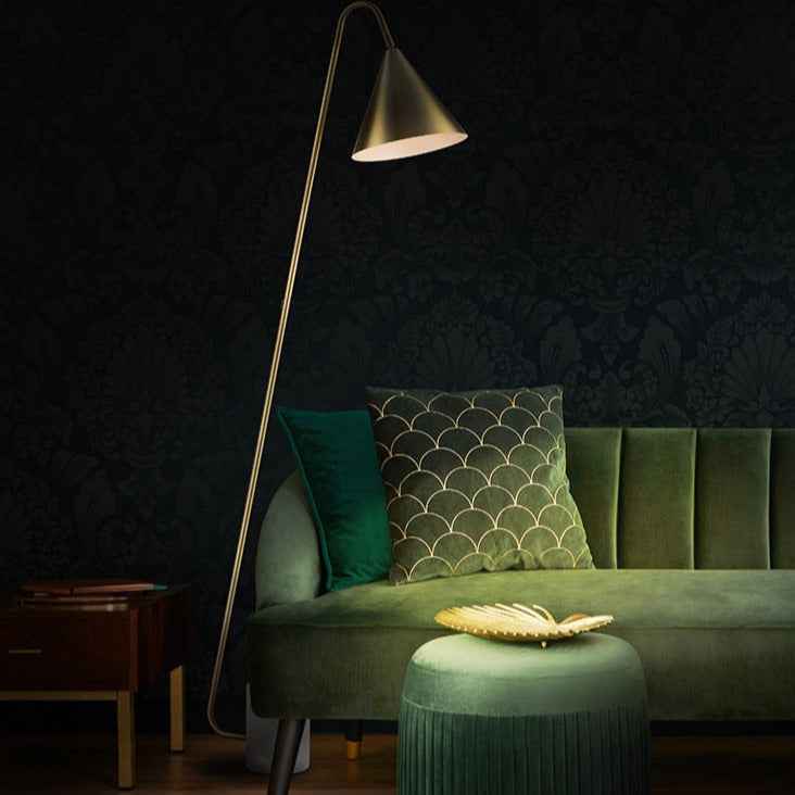 Gilt metal floor lamp with white marble base in a reading corner