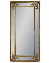 Tall, paneled gilt mirror against a white background.