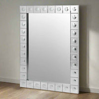 This is a Venetian-style wall mirror featuring a striking raised decorative frame. The rectangular mirror is bordered by a geometric design of square mirrored tiles, each accented with a raised circular dome detail that adds dimension, texture, and light-catching elegance. The reflective frame enhances the mirror’s brilliance, making it not only functional but also a bold decorative statement.

Its clean lines and sculptural frame give it a contemporary twist on classic Venetian design, making it versatile 