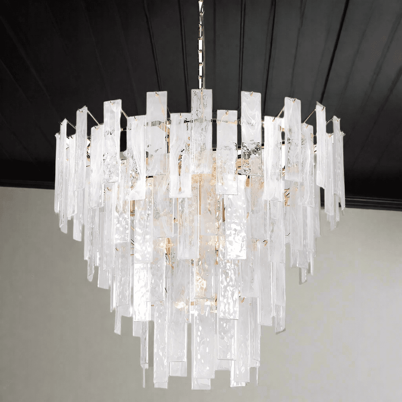 Textured glass four tiered chandelier on a gilt metal frame, a statement in any room. Sixteen bulbs glow through the glass, giving a diffused, ambient light. 
