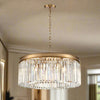 Round 60 cm chandelier with a brushed gold band and vertical crystal prisms, suspended from a gold chain.
