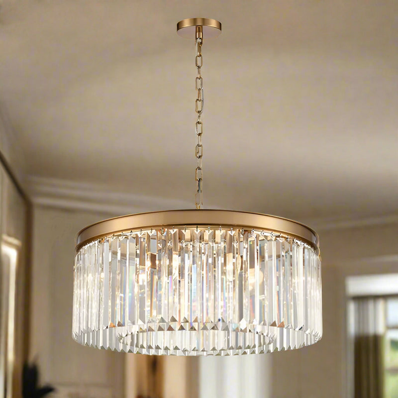 Round 60 cm chandelier with a brushed gold band and vertical crystal prisms, suspended from a gold chain.