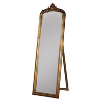 Tall, gold dressing mirror on stand with an ornate gold top.