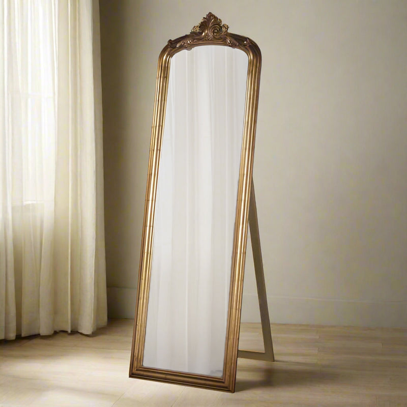 Tall, gold dressing mirror on stand with an ornate gold top.
Ornate standing mirror in gold with an ornate gold top and a movable stand which you can flick out or pull in to lean on the wall. Perfect for a glamorous dressing room or bedroom