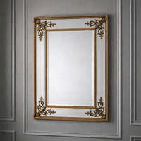 Ornate gilt mirror on a grey paneled wall, simple, neutral background.