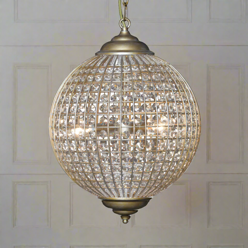Gold Globe Chandelier available in two sizes 50cm or 40cm wide. Crystal beading encased in brushed gold metalwork reflects a pretty pattern around your ceiling and walls. A classic hanging pendants which compliments all types of decor.