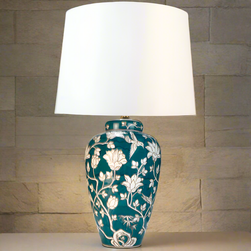 Tall green and white floral swirl ceramic base table lamp with white shade. Stunning floral green and white lamp with large ivory coloured white shade. Ceramic lamps are a staple of English country house decor but usually in a blue and white colour, this is different take on the theme in a striking deep green and white. You can find a wide range of these classic ceramic lamps and shades on our website, in many colours and sizes.&nbsp;