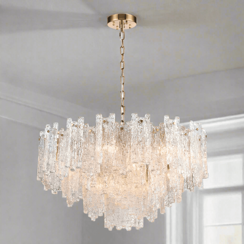 Icicle shard chandelier with textured glass panels at varying heights to refract the lights. It has 16 lights and aged brushed brass metal fittings.