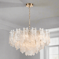 Icicle shard chandelier with textured glass panels at varying heights to refract the lights. It has 16 lights and aged brushed brass metal fittings.