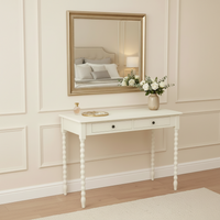 Ivory painted dressing table with two drawers and turned legs in a bedroom