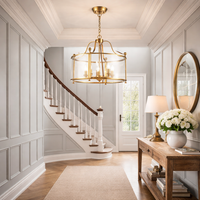 5 light gilt metal lantern features a clear glass drum shade in an entryway