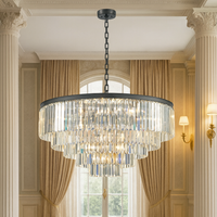 This five-tier chandelier brings timeless glamour and modern elegance together in one striking centerpiece. Its sleek black band frames cascading layers of crystal prisms, creating a dramatic waterfall effect that shimmers beautifully from every angle