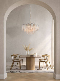 Icicle shard chandelier with textured glass panels at varying heights to refract the lights. It has 16 lights and aged brushed brass metal fittings.