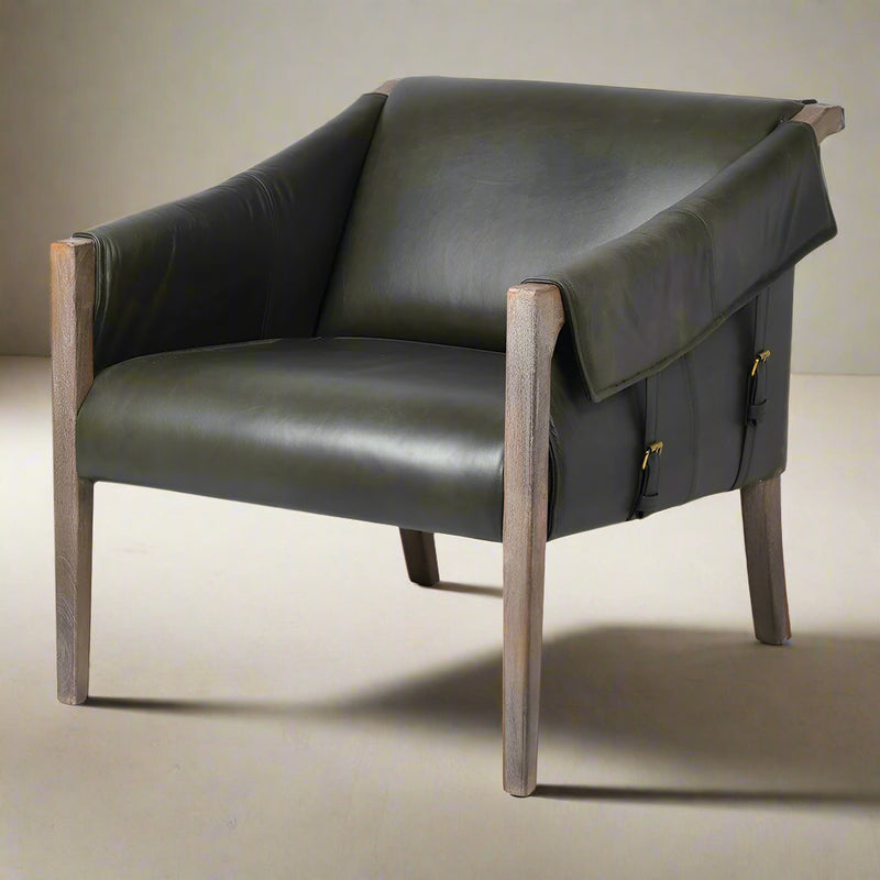 Vintage style leather armchair with two straps to each side.&nbsp;&nbsp; A mid-century style with low slung back on a mango wood frame. A contemporary design perfect in a modern interior in a dark vintage style leather. The addition of antique brass studs to the reverse of the chair and brass metal accents to the straps all add to the vintage feel of this luxury chair.