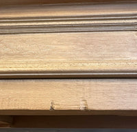 Close-up of a light natural wood surface with visible grain and a horizontal grooved line across the top.
