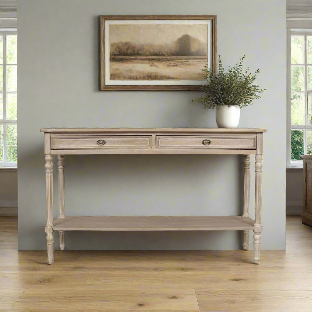 A classic long console table with two useful draws and lower shelf for storage. A hardwood piece made from Mindi wood, finished in an ash lime wash veneer finish in a country cottage setting.