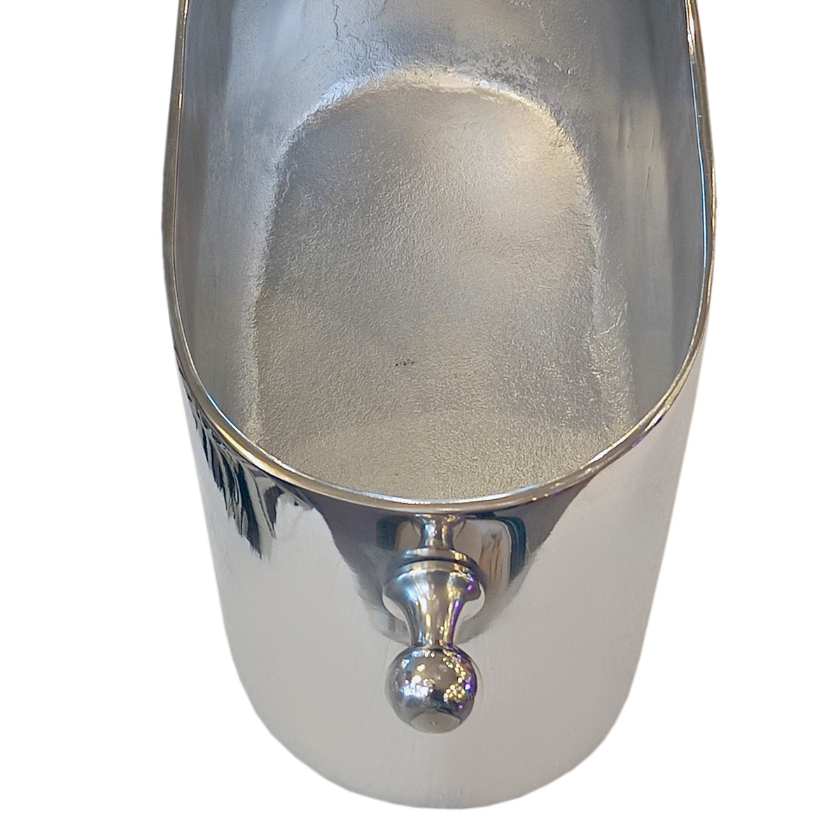 A close-up of a polished silver metal scoop or ice bucket with a rounded handle, shown against a plain white background.