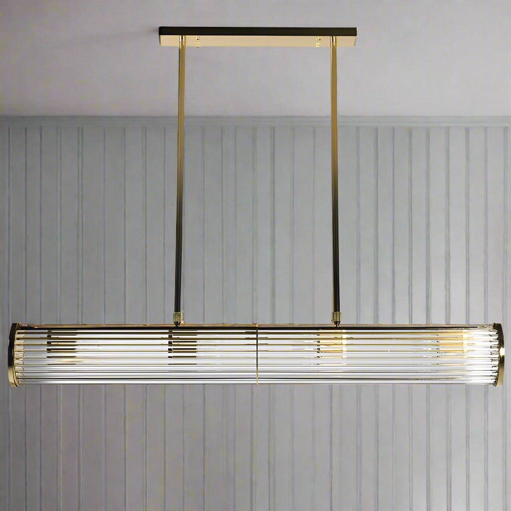 Long glass tubular, linear light, set on two gilt bars and a gilt coloured roof plate. The ends of the long bar are enclosed by two round gilt discs. Great Island light.
